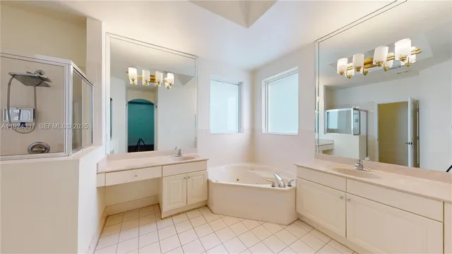 a bathroom with a granite countertop sink a large mirror and a bathtub