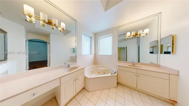 a large white bathroom with a double vanity sink a mirror and a bathtub