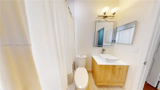 a big room with wooden floor a chandelier and windows