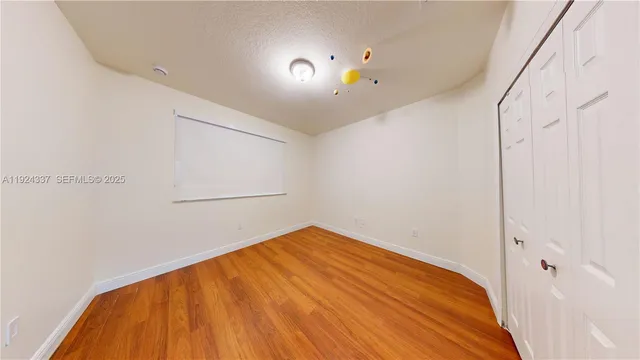 a view of empty room with wooden floor