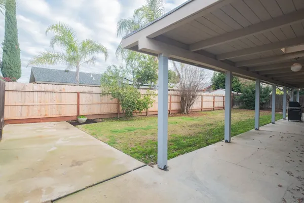 a view of a house with backyard and floor to ceiling window