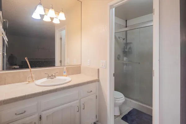 a bathroom with a sink a toilet and shower