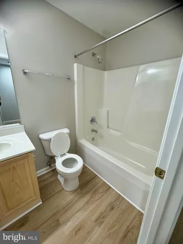 a white toilet sitting next to a bath tub and a shower