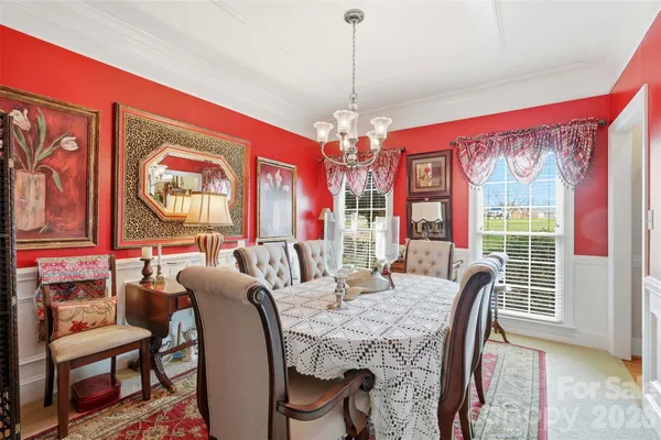 a view of a dining room with furniture a chandelier and wooden floor