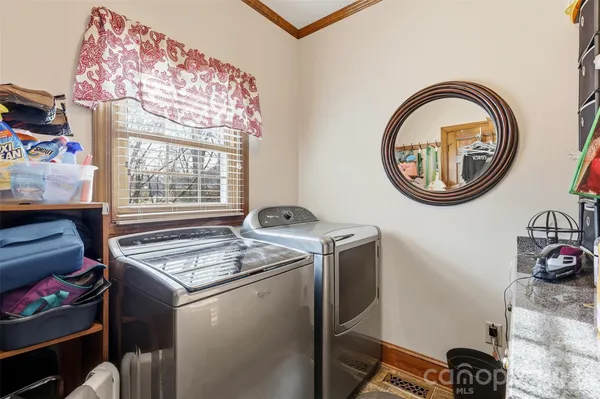 a spacious bedroom with a bed a chandelier and a mirror