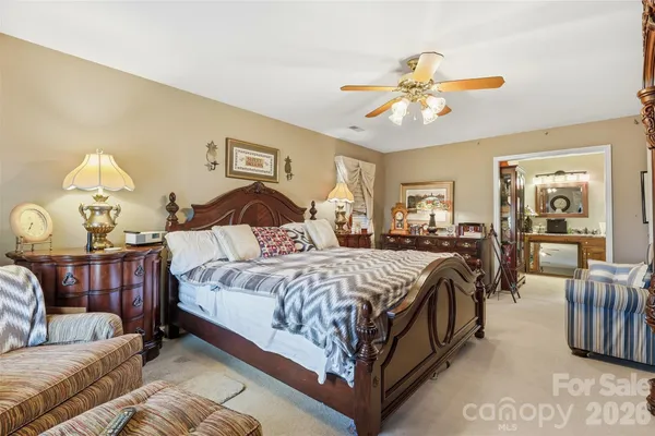 a bedroom with a large bed and a chandelier