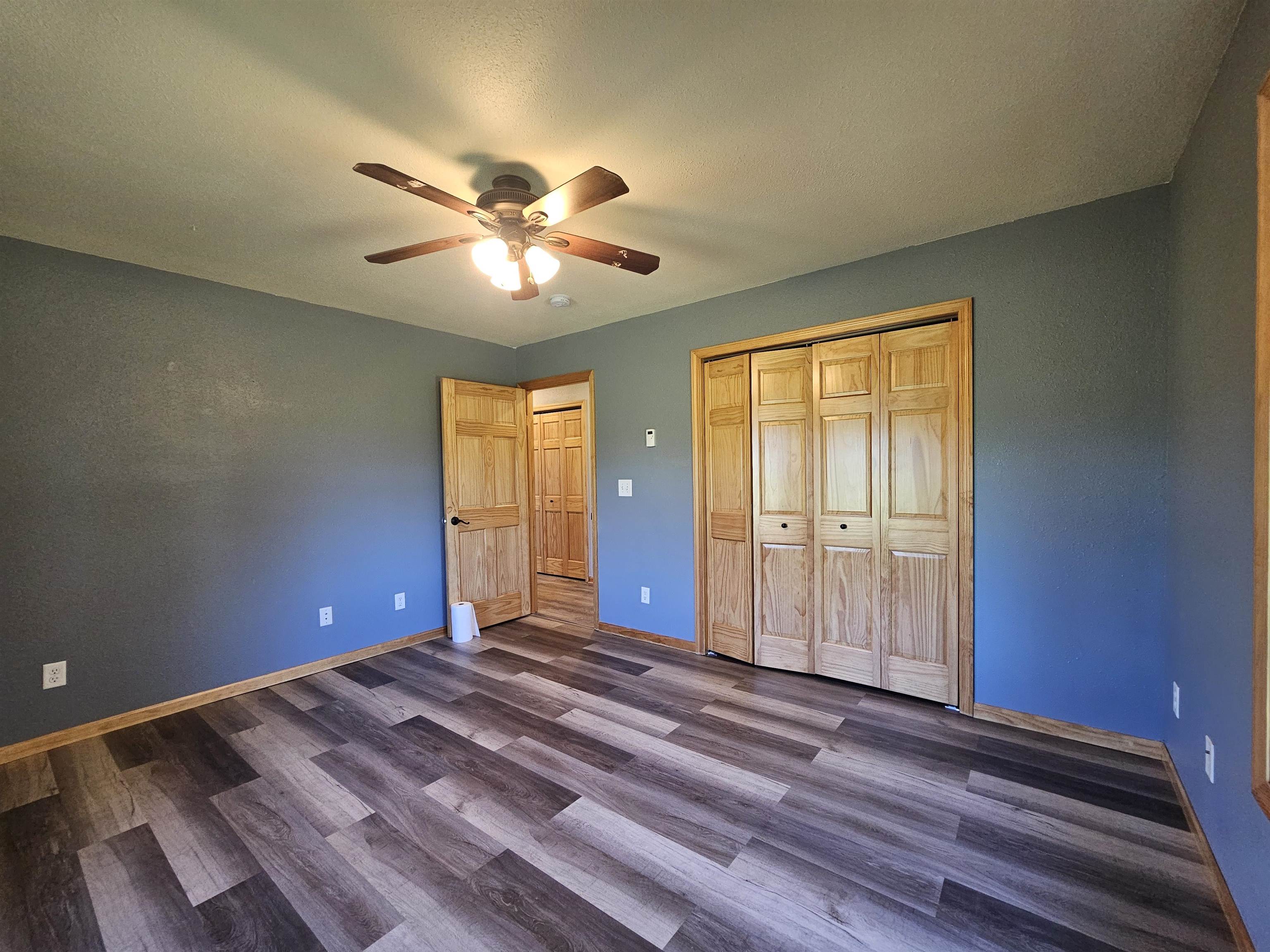 13179 County Rd FF Maple, WI 54854 - Photo 13 of 29 Unfurnished bedroom with dark wood-type flooring, a closet, and a ceiling fan