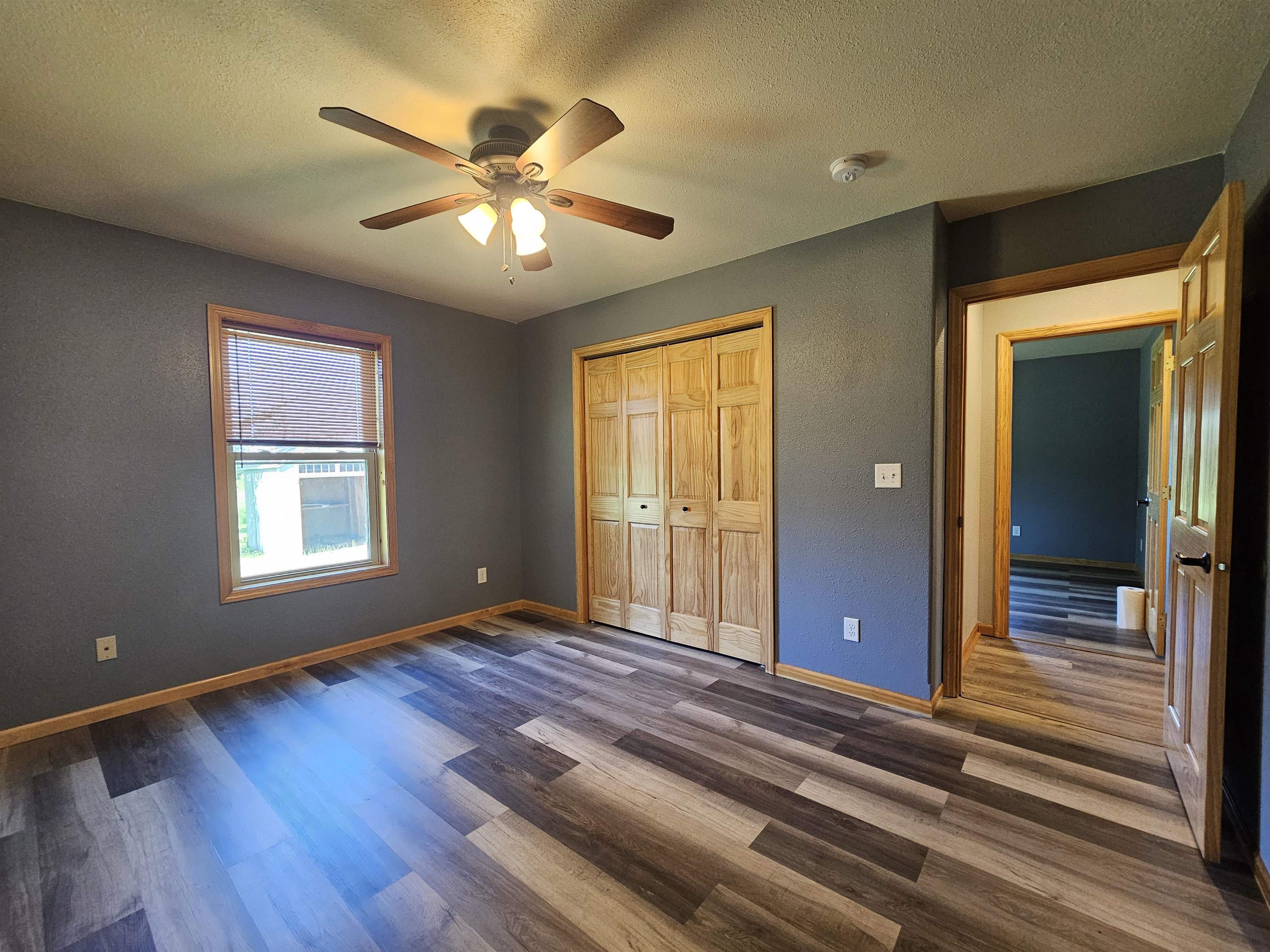 13179 County Rd FF Maple, WI 54854 - Photo 15 of 29 Unfurnished bedroom with dark wood-style flooring, a textured ceiling, a closet, and ceiling fan