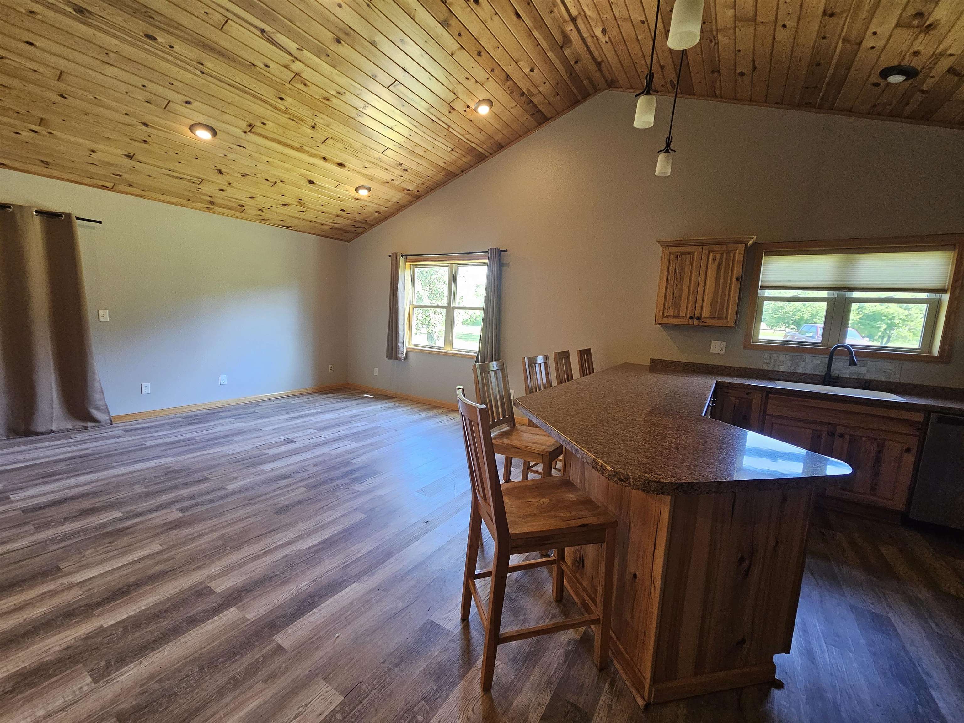 13179 County Rd FF Maple, WI 54854 - Photo 2 of 29 Kitchen with stainless steel dishwasher, lofted ceiling, dark countertops, dark wood-style flooring, and a kitchen breakfast bar