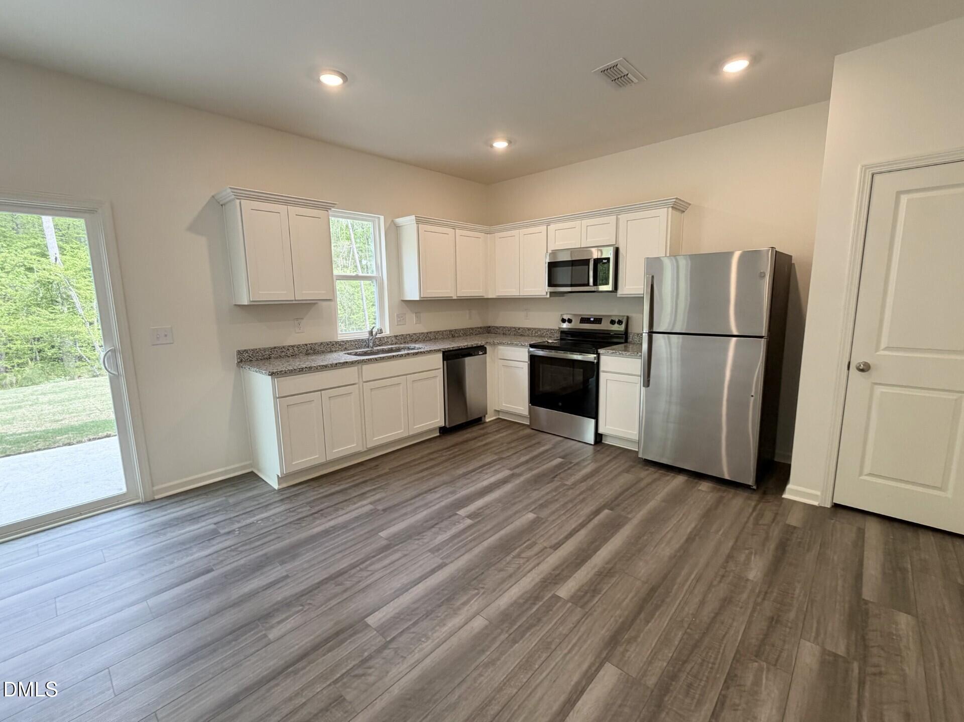 1010 Bombardier Alley Spring Hope, NC 27882 - Photo 10 of 30 a kitchen with a refrigerator a stove top oven a sink and a hard wood floor