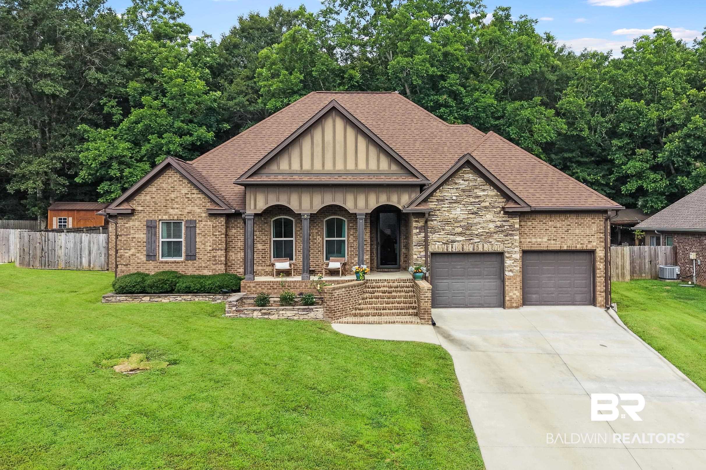 313 Pecan Ridge Boulevard Fairhope, AL 36532 - Photo 25 of 51 Brick and stone-front home featuring a two-car garage, covered entry porch with columns, and a concrete driveway