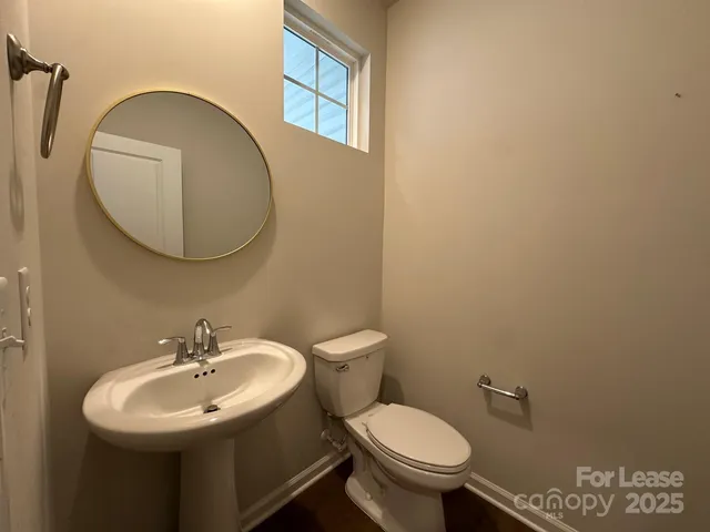 a bathroom with a sink mirror and toilet