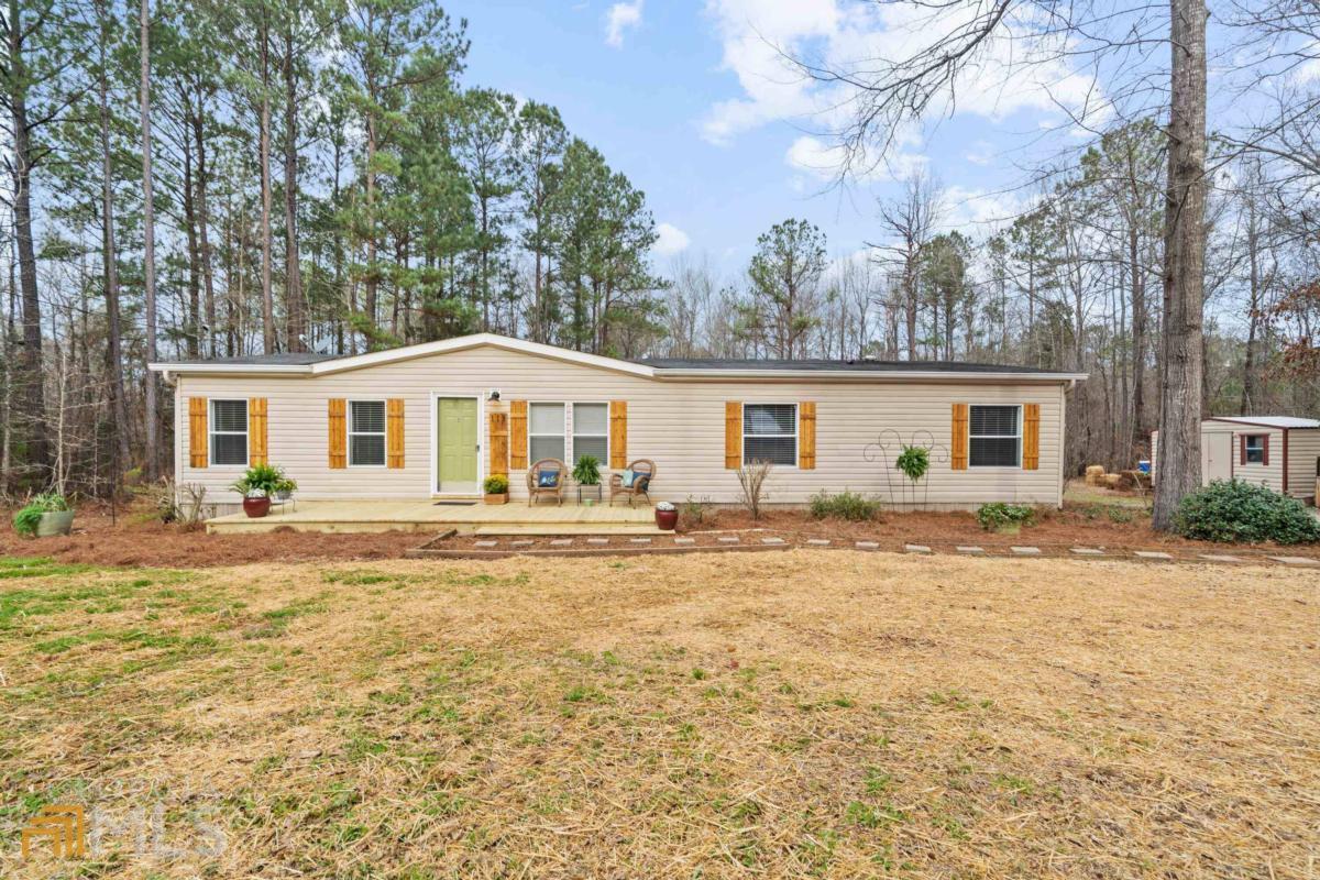 a front view of house with yard and trees around