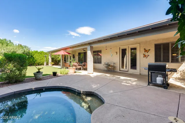 a view of swimming pool with outdoor seating and a garden