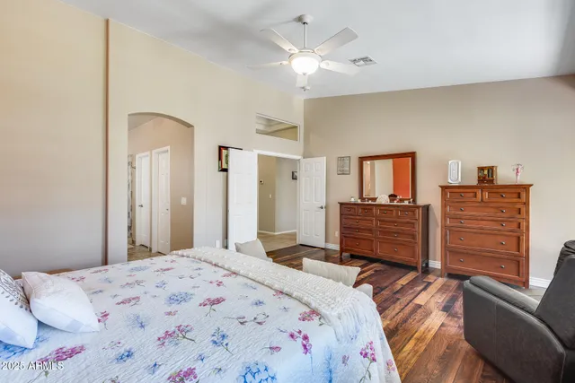 a spacious bedroom with a bed and wooden floor