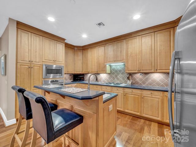 a kitchen with stainless steel appliances granite countertop wooden cabinets a sink and a stove