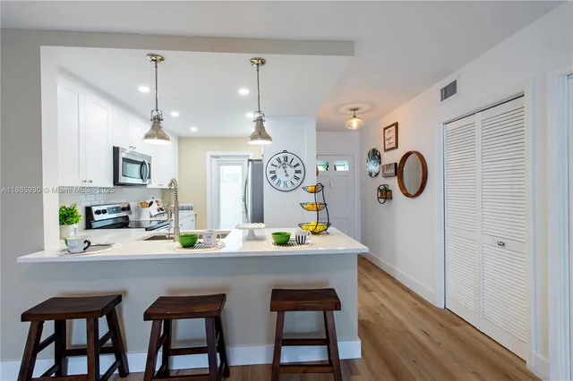 a dining room with stainless steel appliances kitchen island a table and chairs