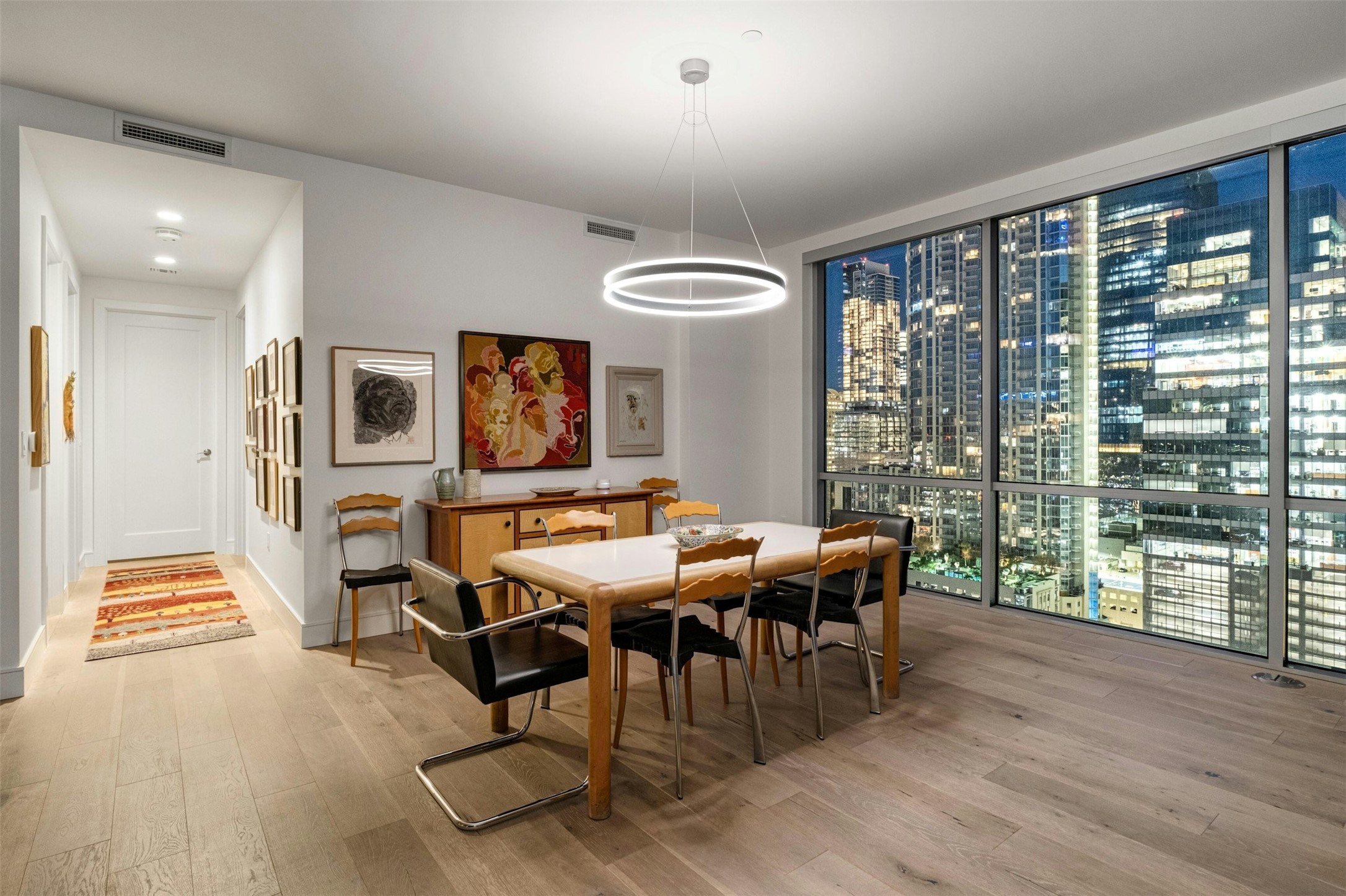 222 West Avenue, Unit 2201 Austin, TX 78701 - Photo 7 of 37 a view of a dining room with furniture wooden floor and chandelier