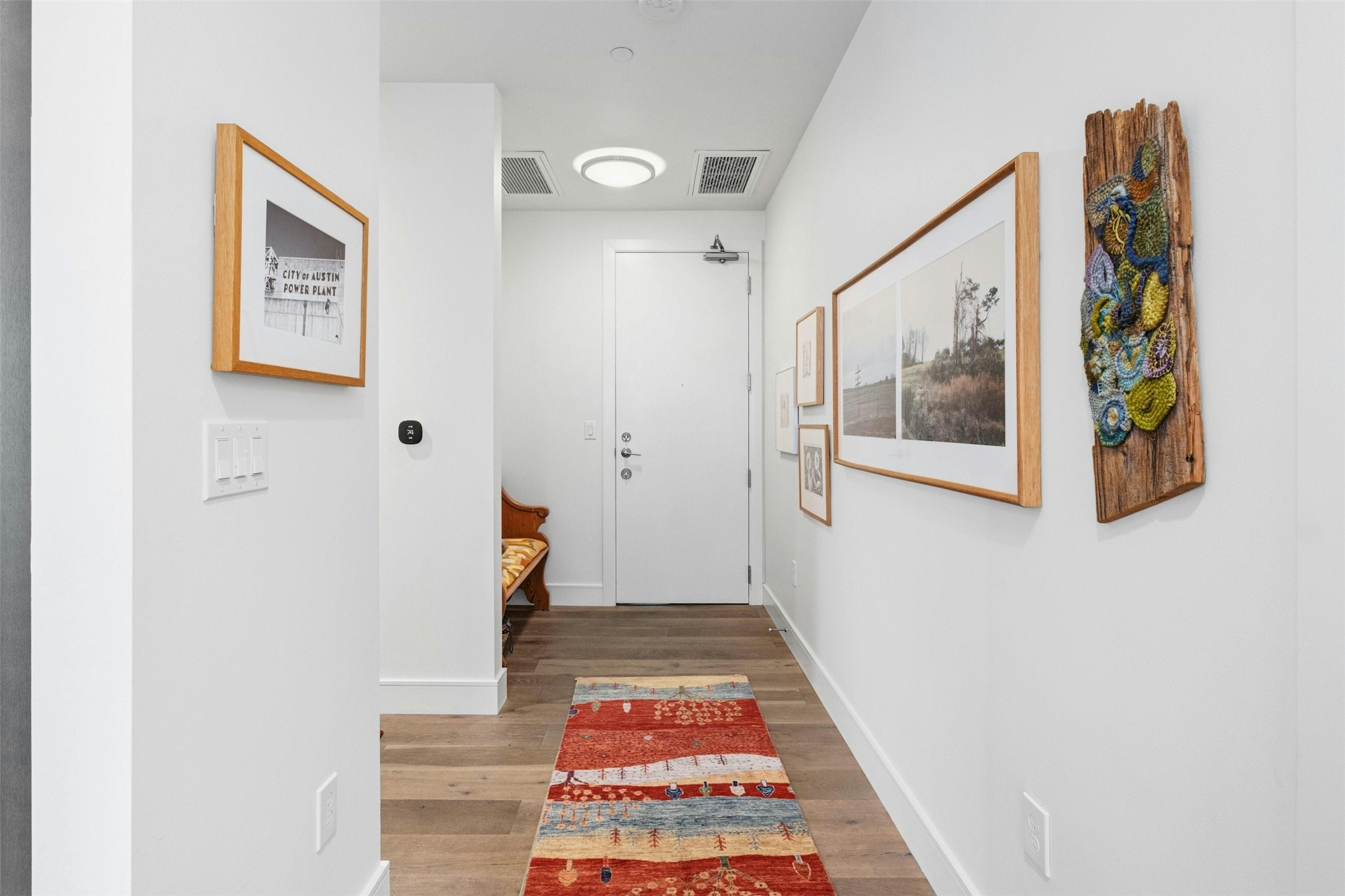 222 West Avenue, Unit 2201 Austin, TX 78701 - Photo 10 of 37 a view of a hallway with wooden floor and a bathroom