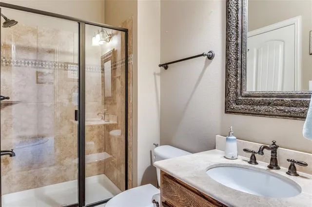 a bathroom with a granite countertop sink mirror and a shower