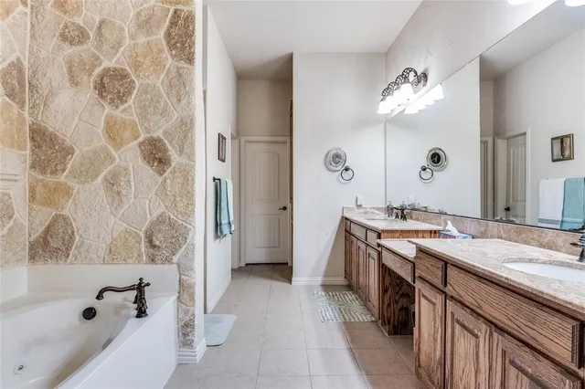 a spacious bathroom with a granite countertop sink a mirror a bathtub and shower