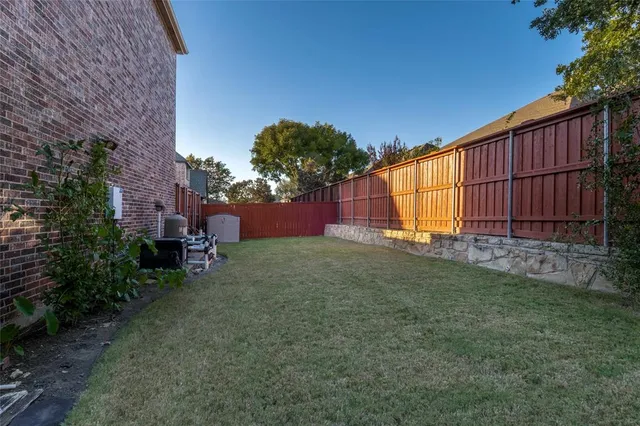 a view of backyard with potted plants and wooden fence
