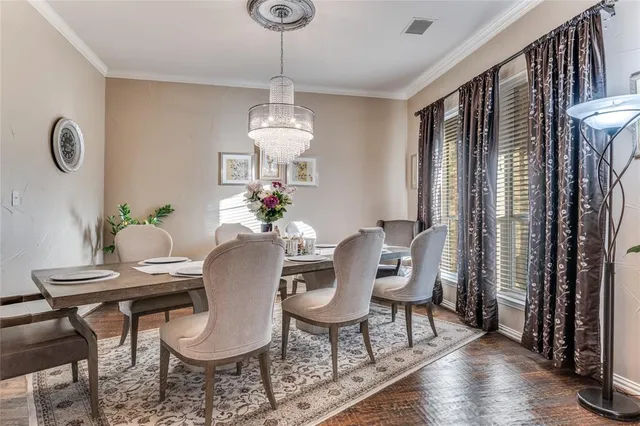 a dining room with furniture a chandelier and wooden floor
