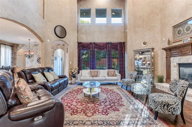 a living room with furniture a fireplace and a chandelier