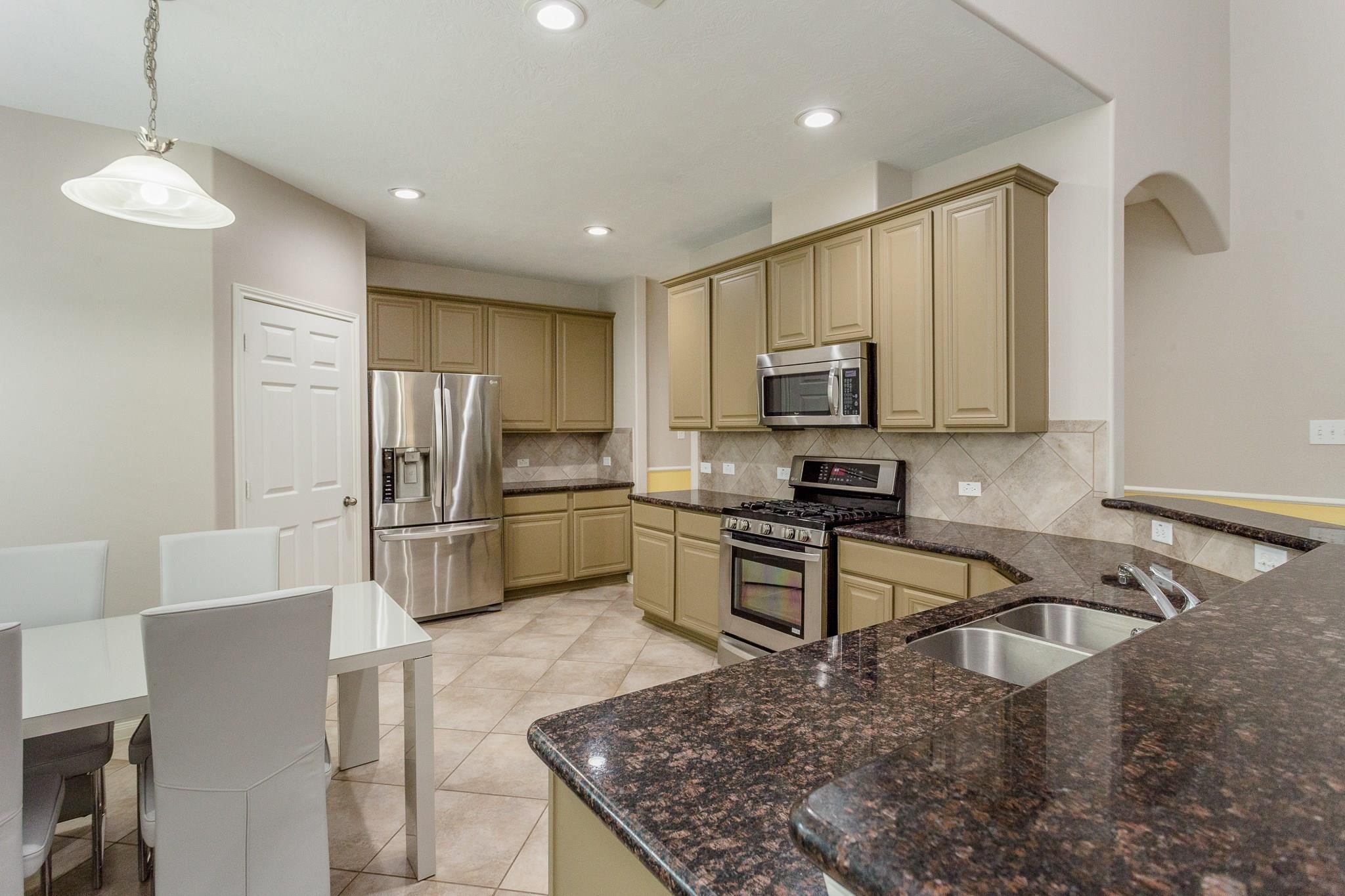 3430 Lilac Ranch Drive Katy, TX 77494 - Photo 11 of 29 a kitchen with stainless steel appliances granite countertop a sink refrigerator and microwave