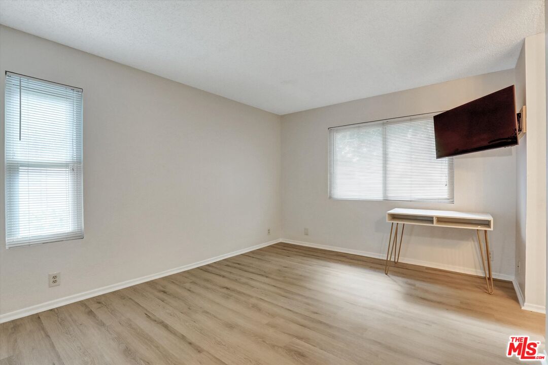 82 Eagle Point, Unit 43 Irvine, CA 92604 - Photo 19 of 35 an empty room with wooden floor cabinet and windows