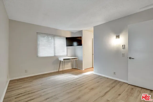 a view of room with window and wooden floor
