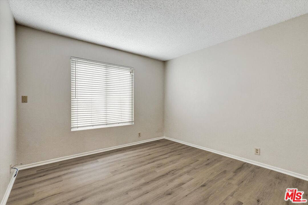 82 Eagle Point, Unit 43 Irvine, CA 92604 - Photo 23 of 35 an empty room with wooden floor and windows