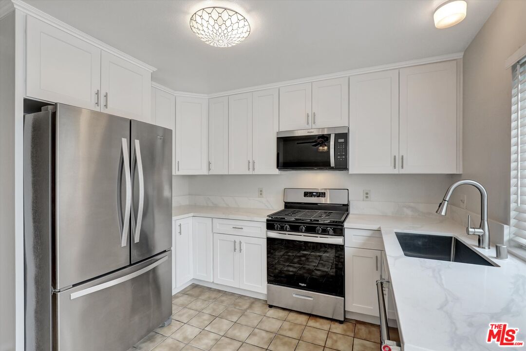 82 Eagle Point, Unit 43 Irvine, CA 92604 - Photo 4 of 35 a kitchen with stainless steel appliances granite countertop a refrigerator stove and sink