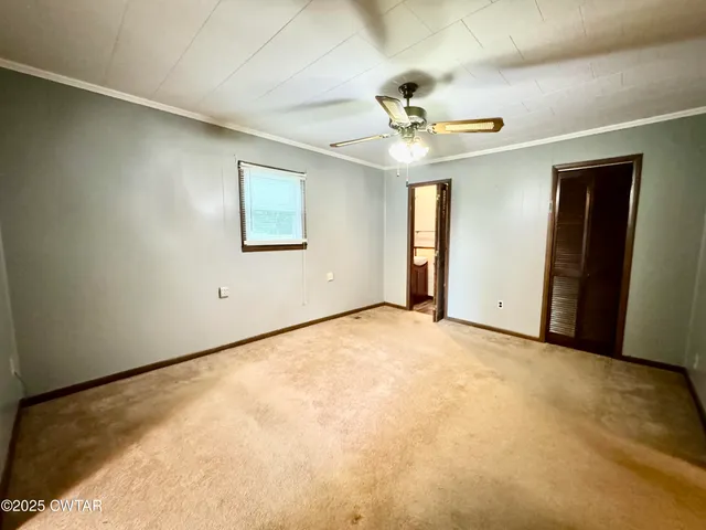 an empty room with a ceiling fan and a window