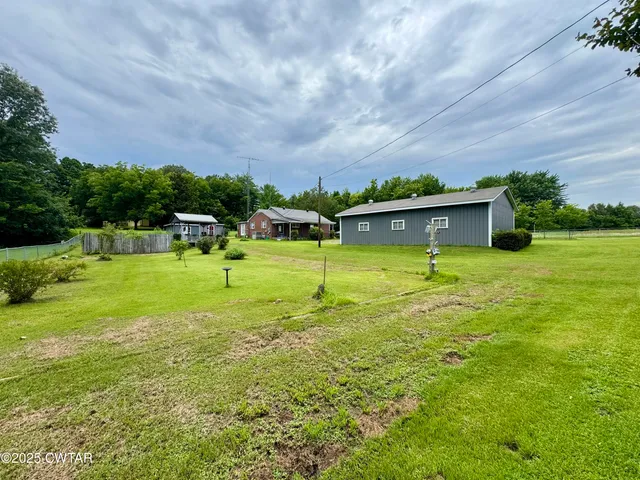a view of a big yard with a house and large trees