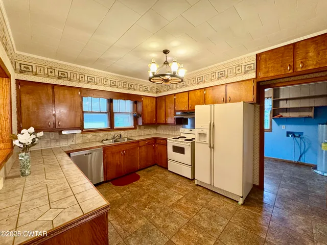 a kitchen with granite countertop a sink stove and refrigerator