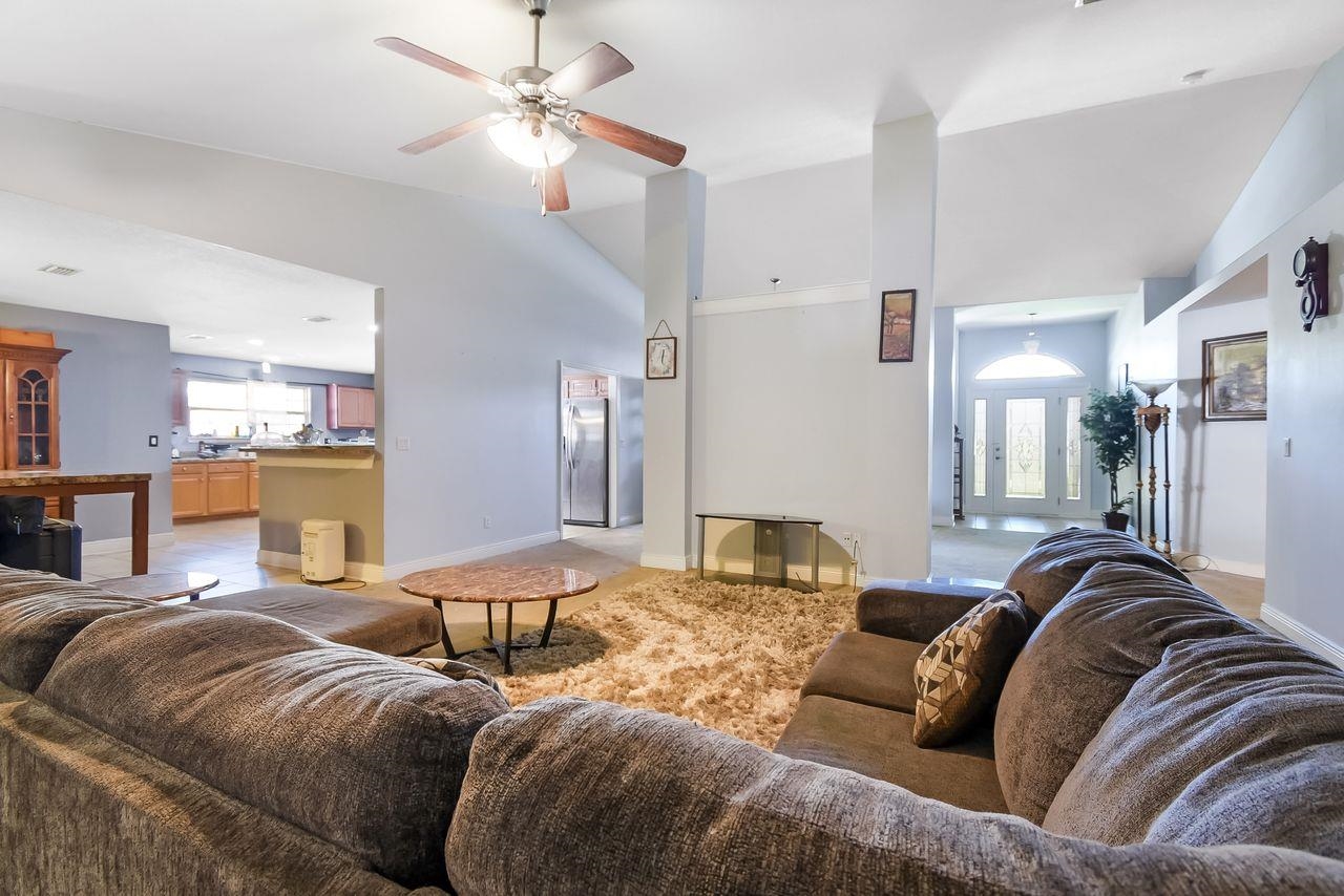 46 Riddle Drive Palm Coast, FL 32164 - Photo 7 of 20 a living room with furniture ceiling fan and a rug