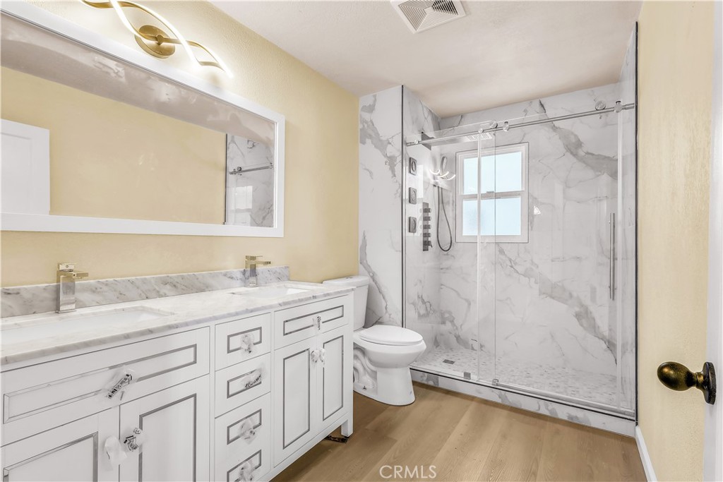 15905 Kugelman Street Lower Lake, CA 95457 - Photo 51 of 75 a bathroom with a granite countertop sink toilet a mirror a vanity and shower