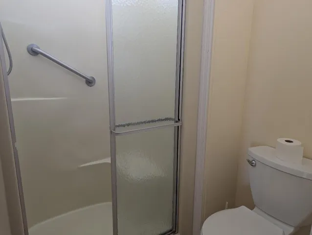 a bathroom with a toilet and a shower