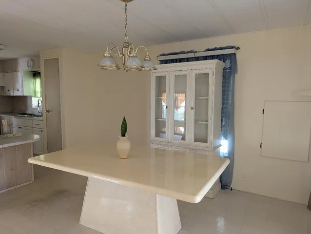 a kitchen with a sink a chandelier and living room view