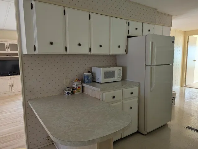 a room with cabinets and a refrigerator