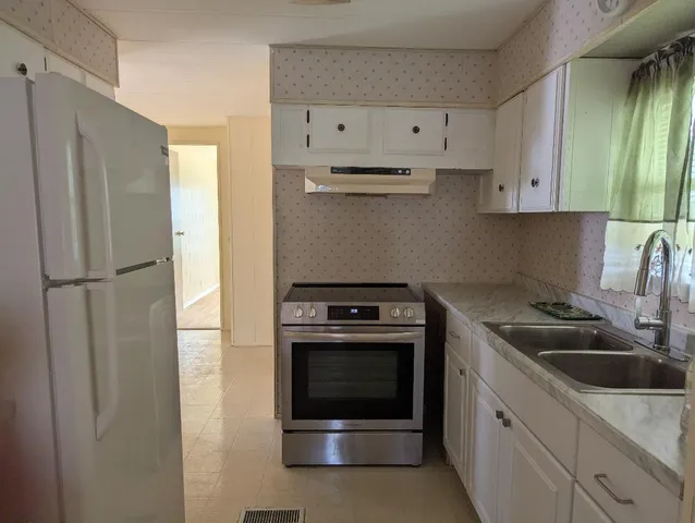 a kitchen with cabinets stainless steel appliances and a sink