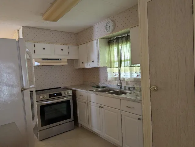 a kitchen with cabinets stainless steel appliances and a window