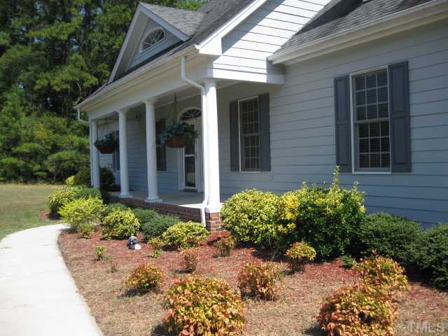 3709 Barwell Road Raleigh, NC 27610 - Photo 23 of 25 a view of a house with potted plants and a large tree