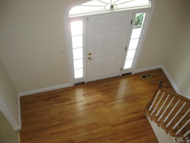 3709 Barwell Road Raleigh, NC 27610 - Photo 6 of 25 a view of an empty room with wooden floor and a window
