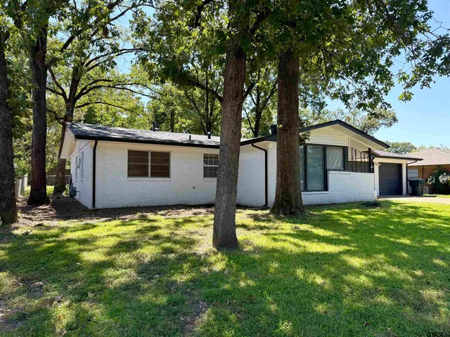 a view of a patio with table and chairs and potted plants with wooden fence