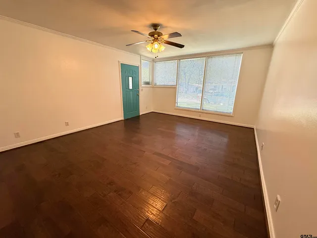 wooden floor in an empty room with a window