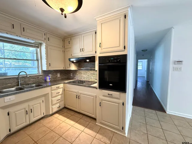 a kitchen with granite countertop white cabinets and sink