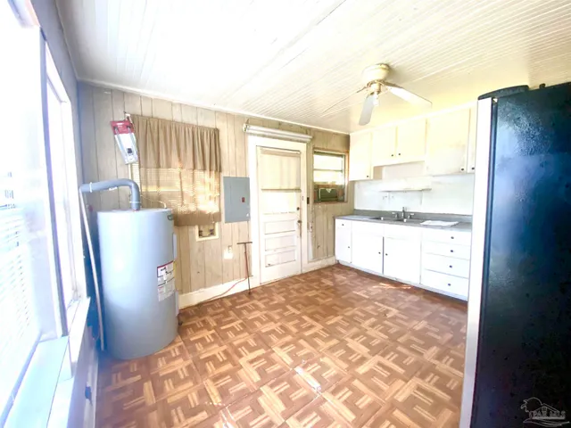 a kitchen with a window a refrigerator and wooden cabinets