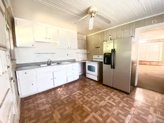 a kitchen with stainless steel appliances granite countertop a refrigerator and white cabinets